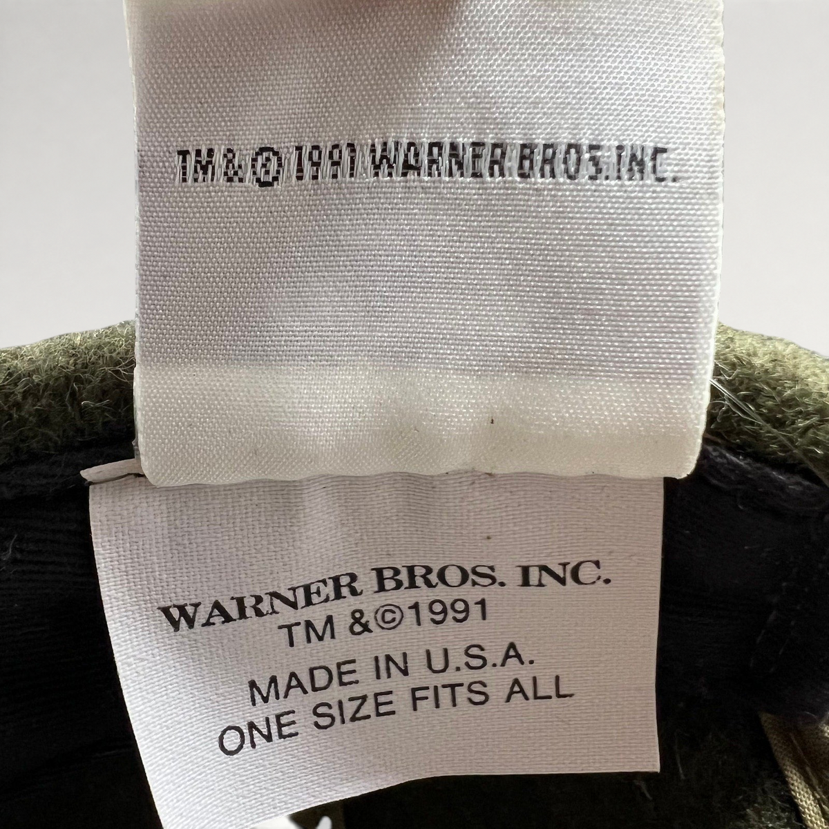 Raree Finds vintage 1991 Warner Bros. interior tag on a Harley-Davidson Taz hat, showing Made in U.S.A. details.