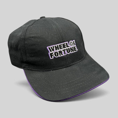 Raree Finds vintage Wheel of Fortune snapback hat in black cotton with purple brim trim and embroidered show logo.