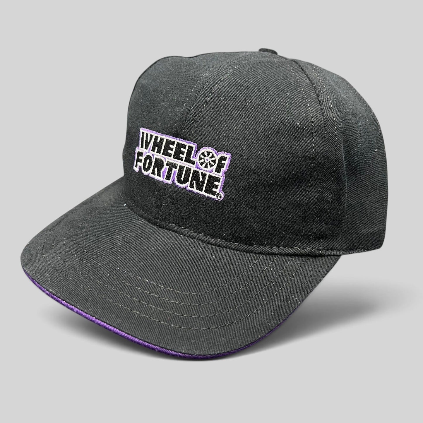 Raree Finds vintage black snapback hat with purple brim accent and embroidered Wheel of Fortune logo