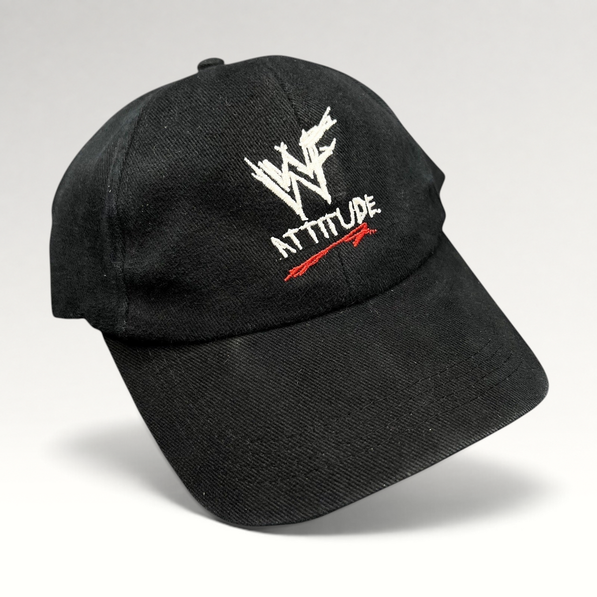 Raree Finds vintage black WWF Attitude Era snapback hat with white scratch logo and red embroidery detail.