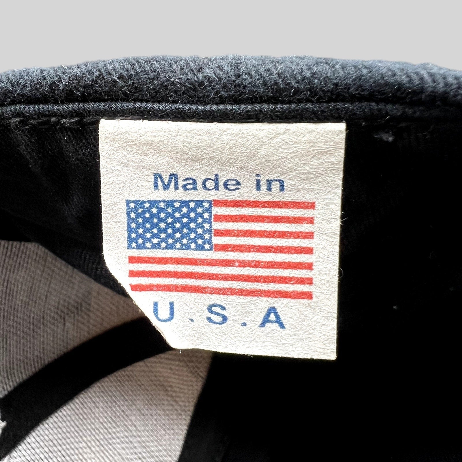 Raree Finds vintage WWF hat interior tag showing Made in USA with an American flag graphic on a black cap