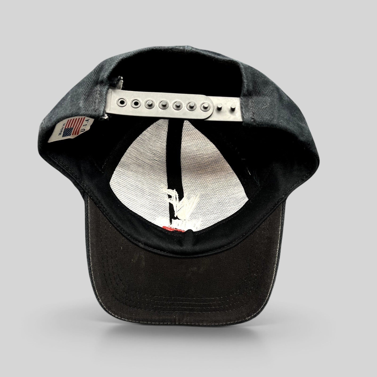 Raree Finds vintage black WWF Attitude Era snapback hat showing the interior label and adjustable plastic snap closure.