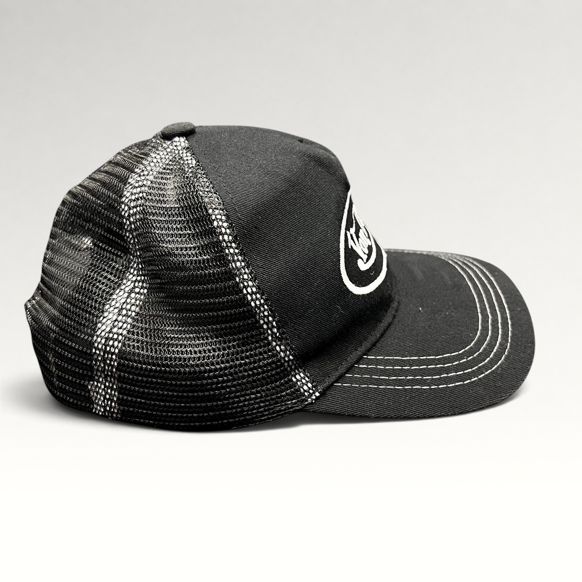 Raree Finds vintage Von Dutch black and white trucker hat with mesh back, curved brim, and embroidered logo.