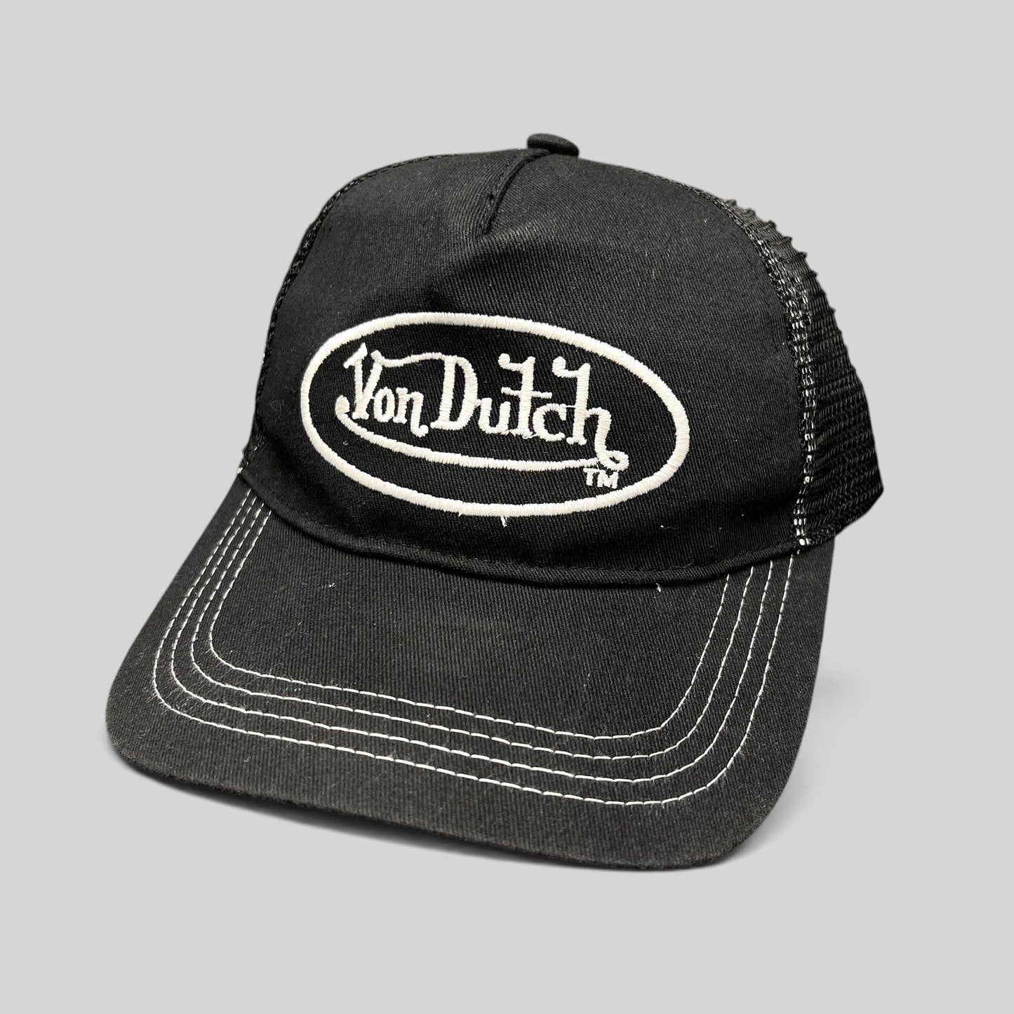 Raree Finds vintage Von Dutch black trucker hat with white oval logo embroidery, mesh back, and contrast stitching.