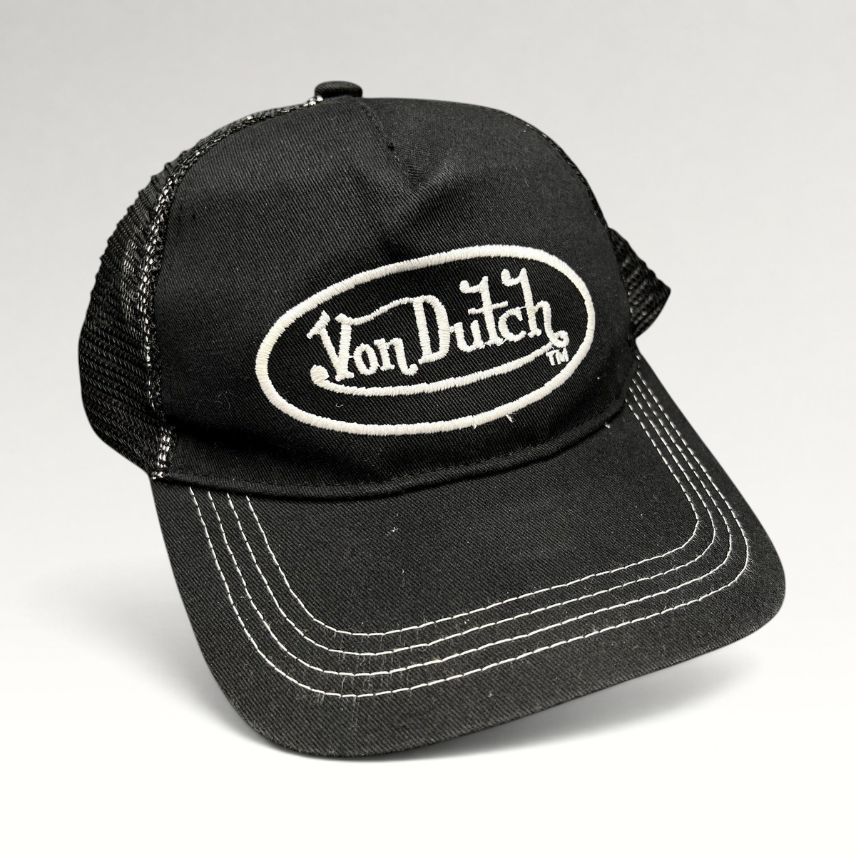 Raree Finds vintage black and white Von Dutch trucker hat with embroidered oval logo and mesh back panels.