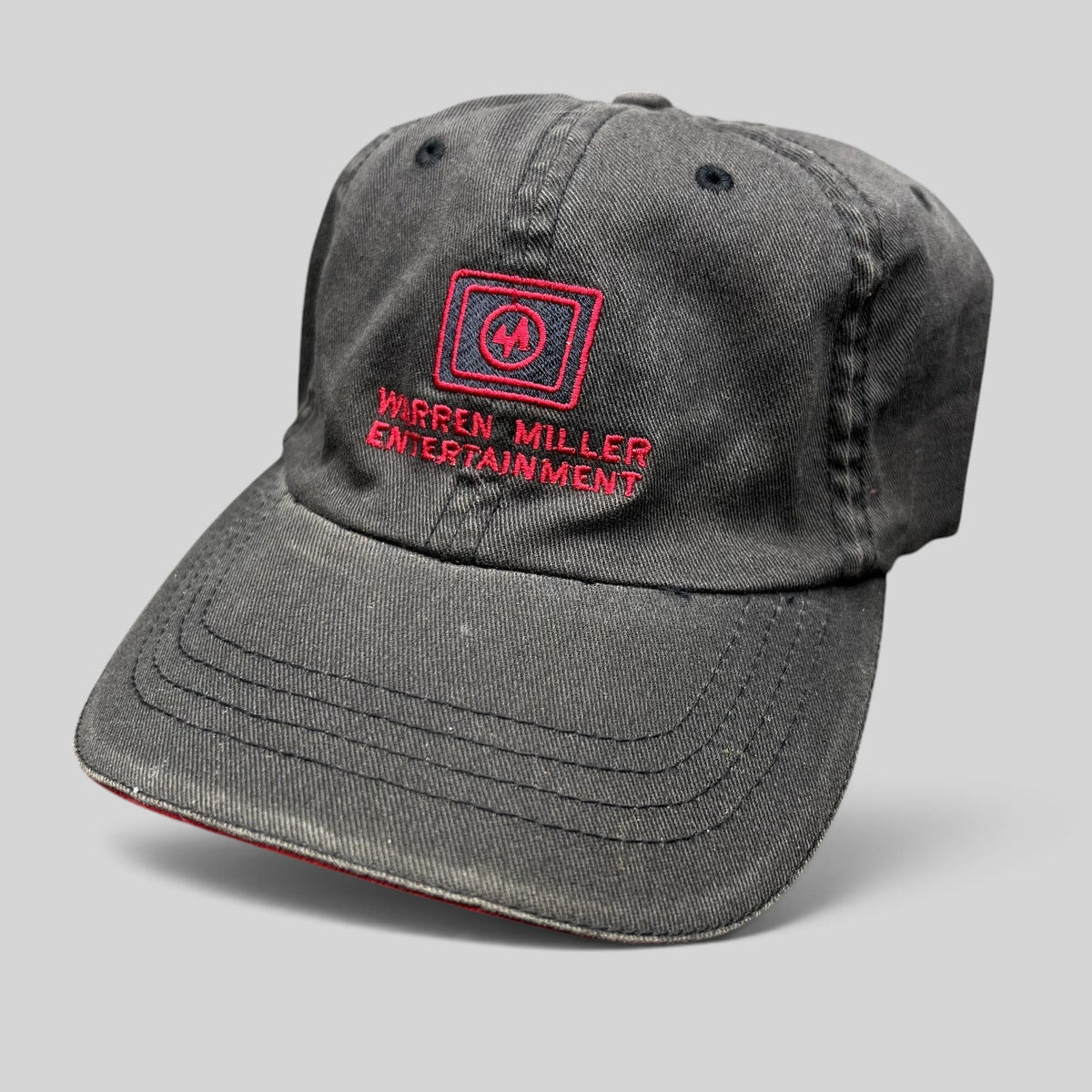 Raree Finds vintage black Warren Miller Entertainment Flexfit hat with red embroidered logo and brim piping