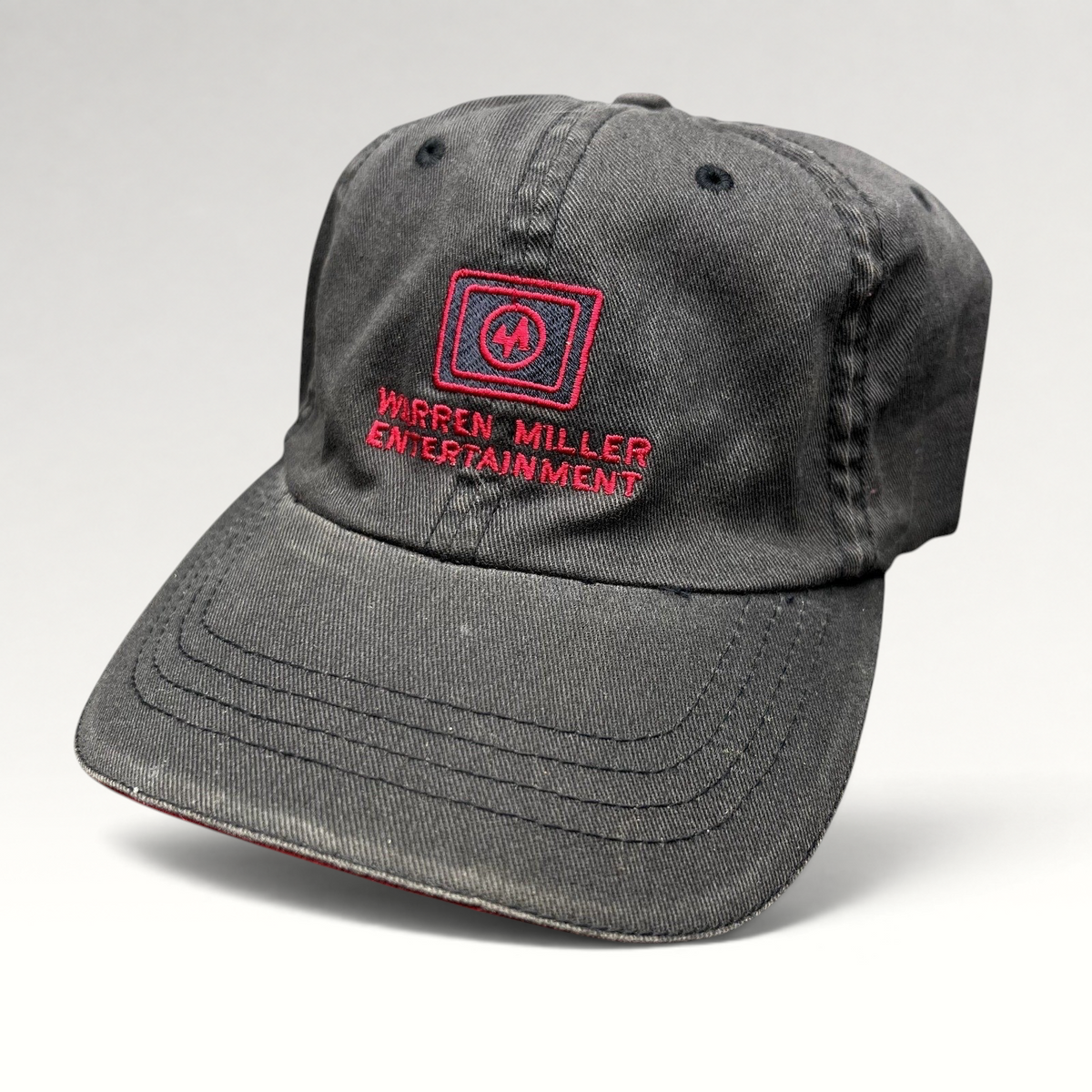 Raree Finds vintage black Warren Miller Entertainment Flexfit hat with red embroidered logo and brim piping