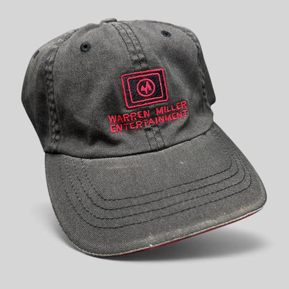 Raree Finds vintage black Flexfit hat with red Warren Miller Entertainment logo embroidery and contrast brim piping.