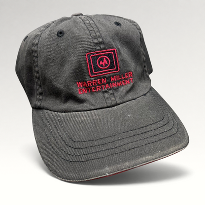 Raree Finds vintage black Flexfit hat with red Warren Miller Entertainment logo embroidery and contrast brim piping.
