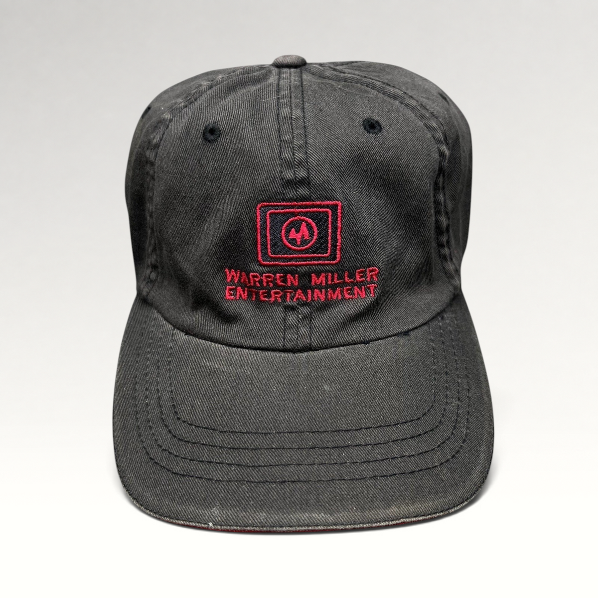 Raree Finds vintage black Warren Miller Entertainment Flexfit hat with red embroidered logo and brim piping