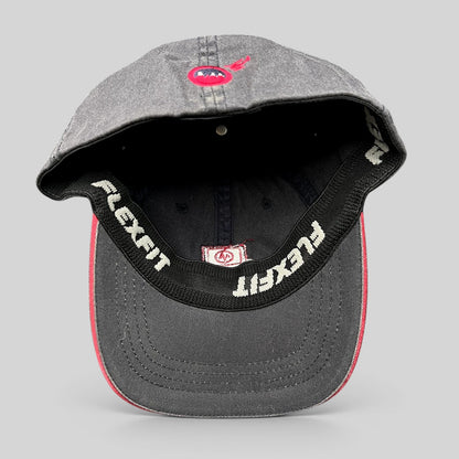 Raree Finds vintage Warren Miller Entertainment Flexfit hat showing the interior black sweatband and red brim piping
