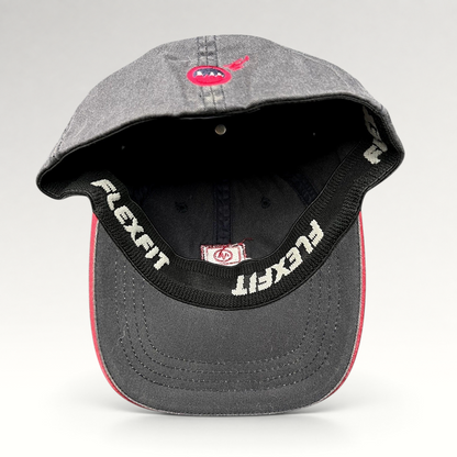 Raree Finds vintage Warren Miller Entertainment Flexfit hat showing the interior black sweatband and red brim piping