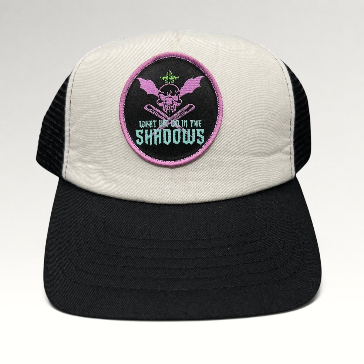 Raree Finds What We Do in the Shadows promo trucker hat with cream foam front, black mesh back, and gothic skull patch