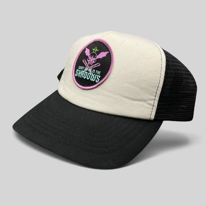 Raree Finds What We Do in the Shadows trucker hat with cream foam front, black mesh back, and gothic skull patch.
