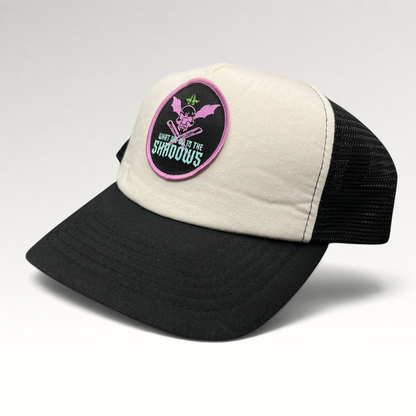 Raree Finds What We Do in the Shadows trucker hat with cream foam front, black mesh back, and gothic skull patch.