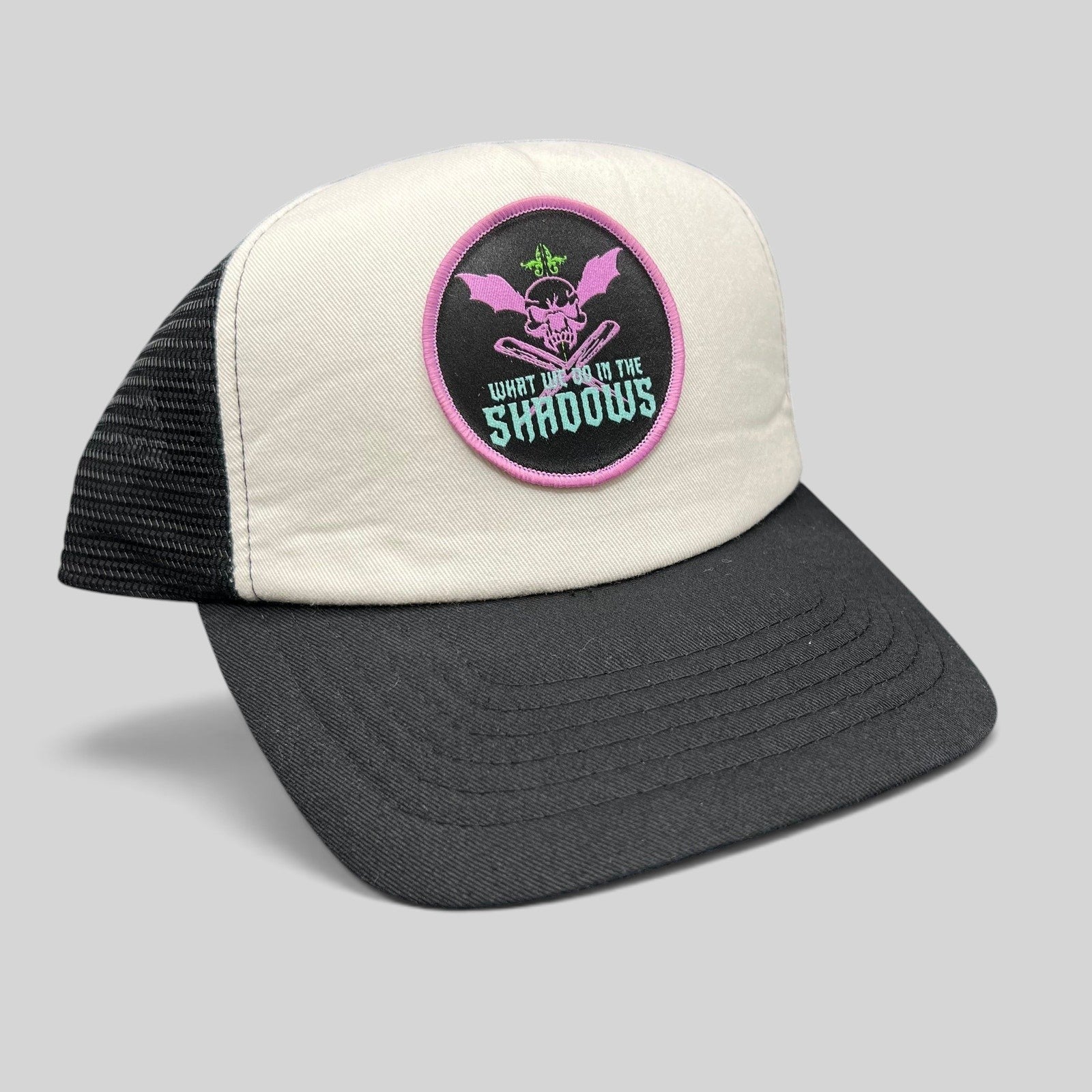 Raree Finds What We Do In The Shadows promo trucker hat with cream foam front, black mesh back, and gothic skull patch