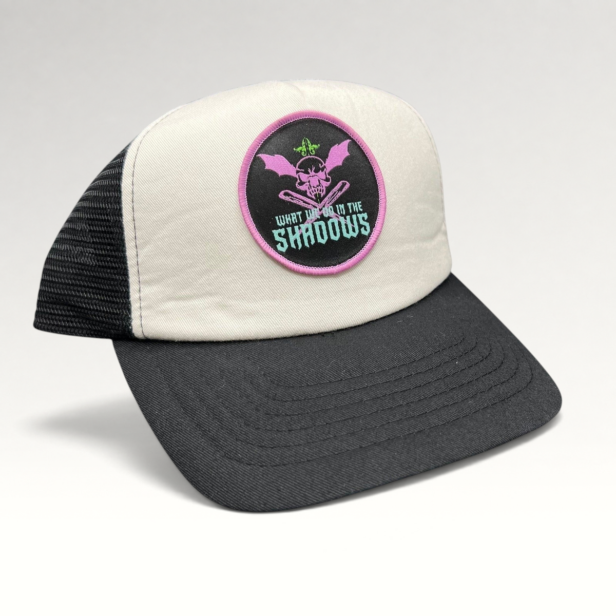Raree Finds What We Do In The Shadows promo trucker hat with cream foam front, black mesh back, and gothic skull patch