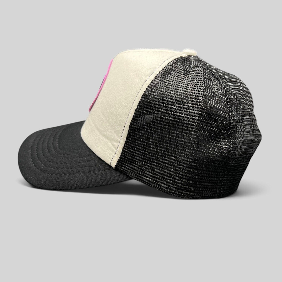 Raree Finds What We Do In The Shadows trucker hat with cream foam front, black mesh back, and gothic graphic patch.
