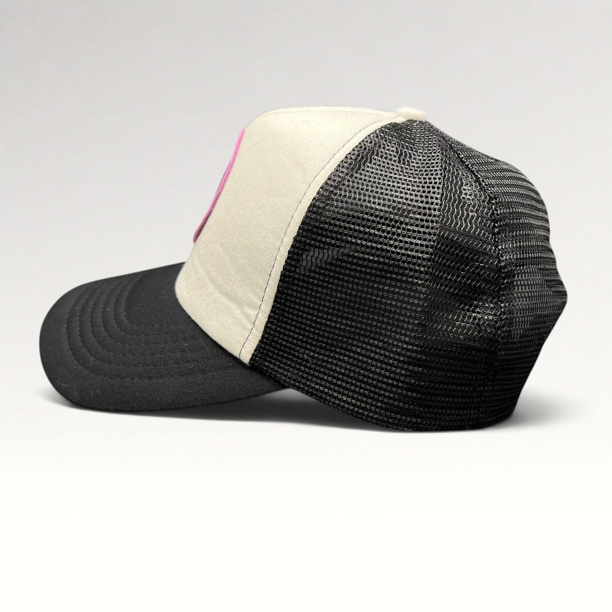 Raree Finds What We Do In The Shadows trucker hat with cream foam front, black mesh back, and gothic graphic patch.