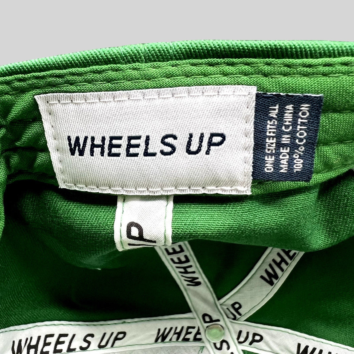 Raree Finds green cotton Wheels Up cap interior label with branded taping and size information