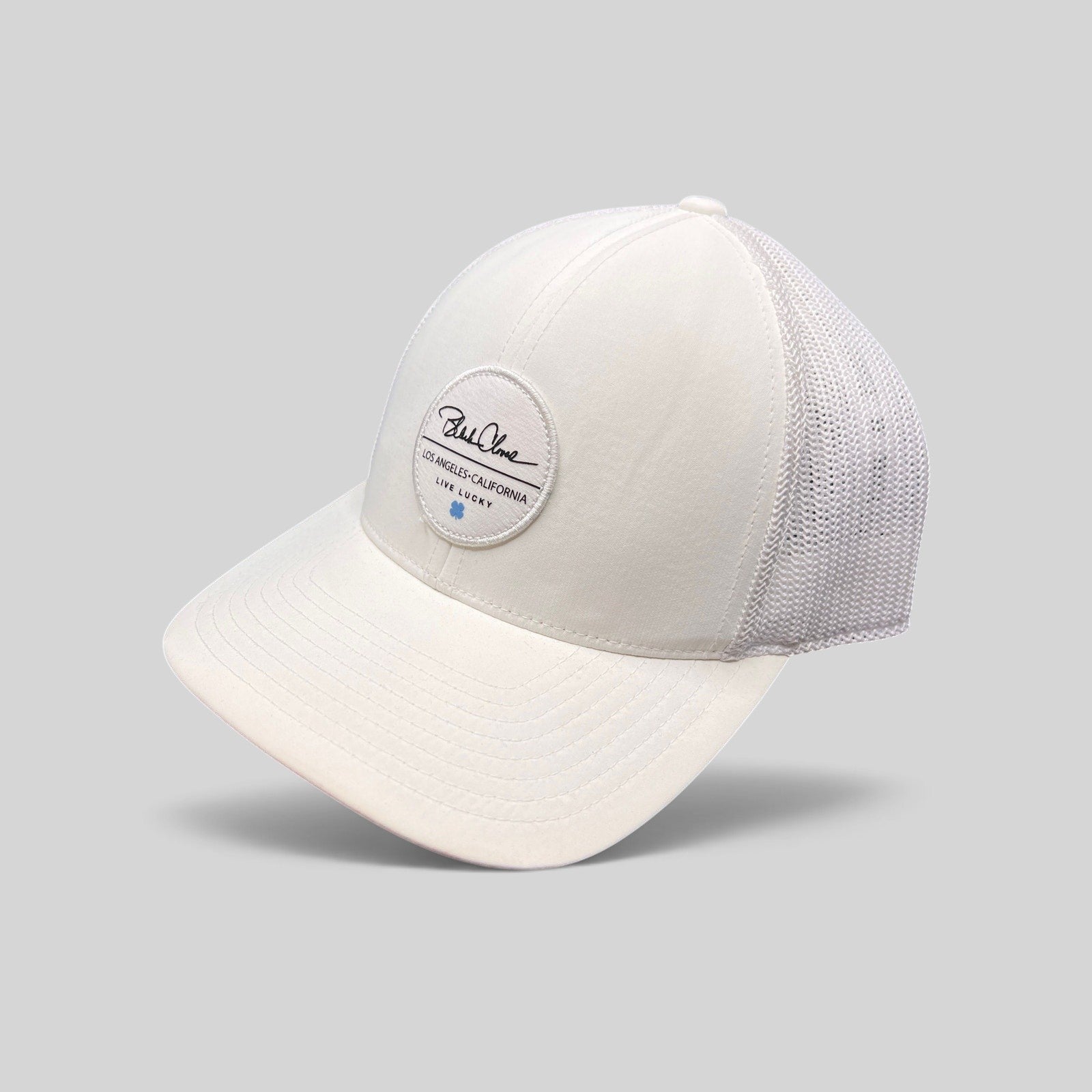 Raree Finds white Black Clover trucker hat with Live Lucky circular patch and blue clover detail on mesh back