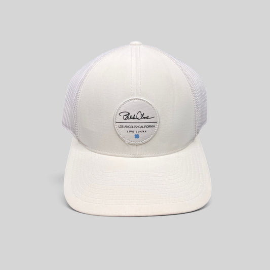 Raree Finds white Black Clover trucker hat with Live Lucky patch and blue clover detail on a structured mesh back