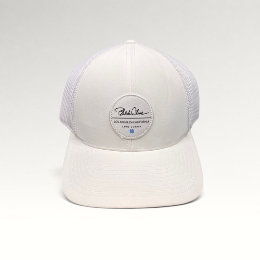 Raree Finds white Black Clover trucker hat with Live Lucky patch and blue clover detail on a structured mesh back