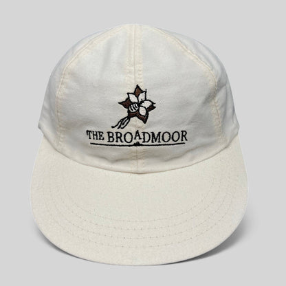 Raree Finds white cotton strapback golf hat featuring The Broadmoor floral logo and script embroidery