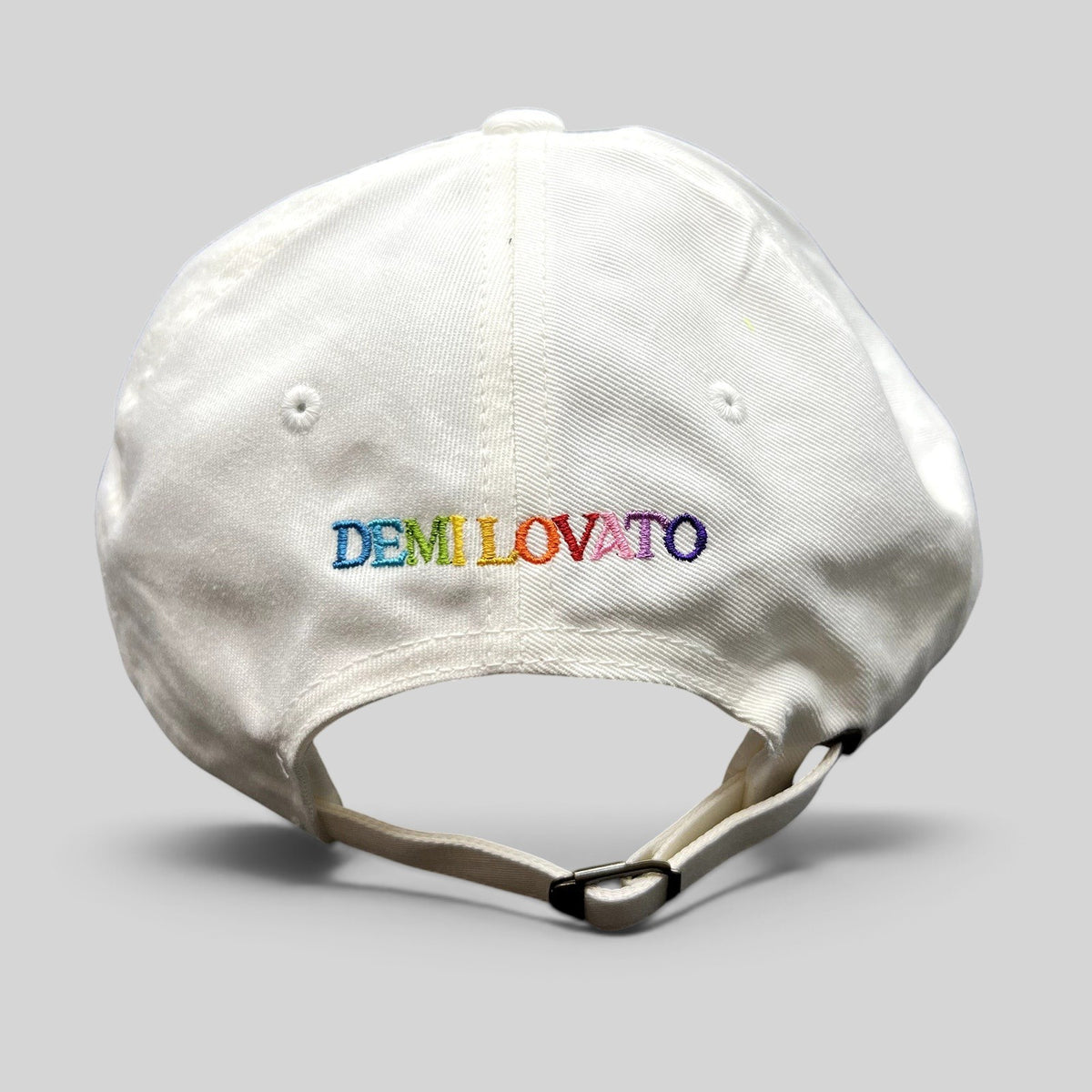 Raree Finds white strapback hat with multicolor Demi Lovato embroidery on the back and adjustable metal strap closure