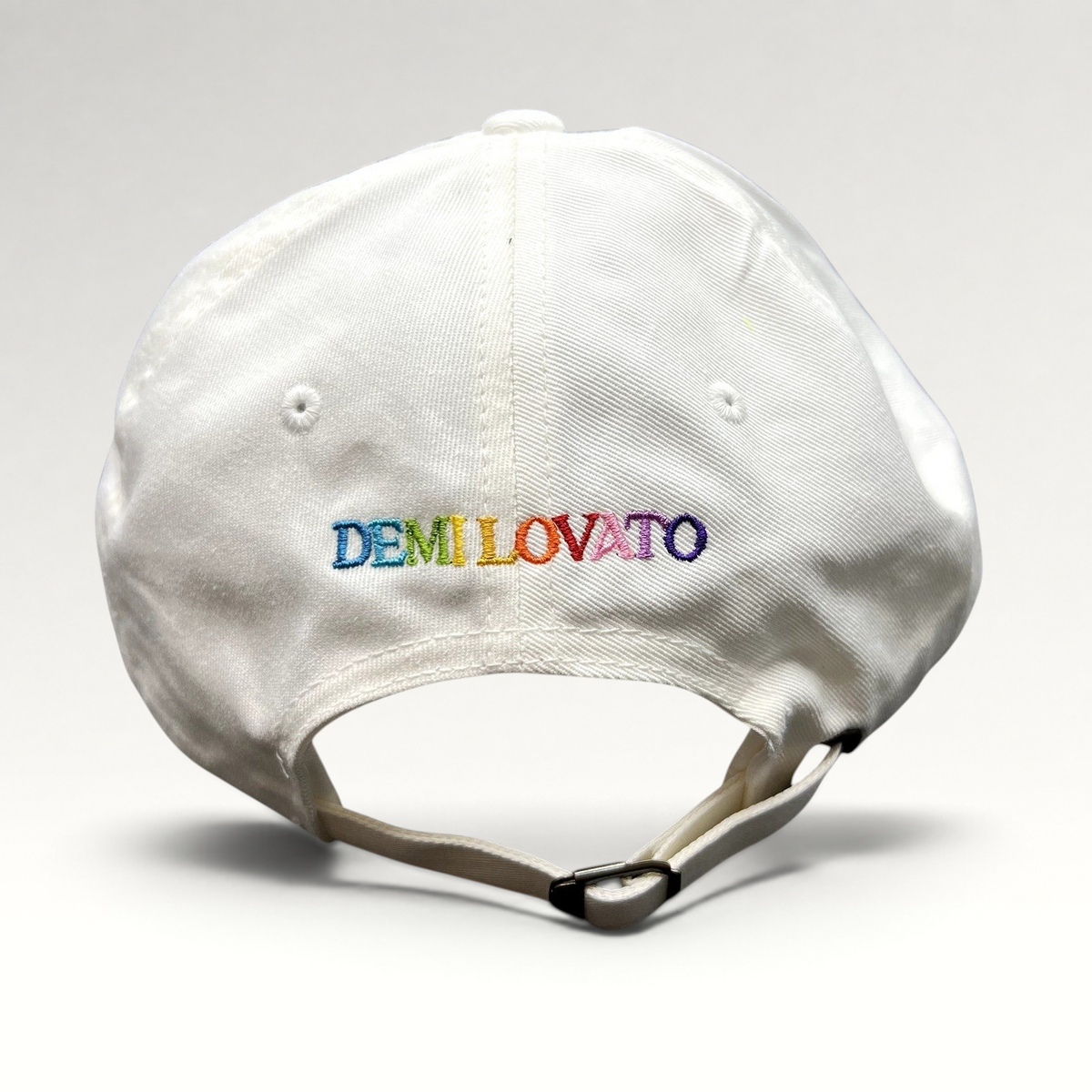 Raree Finds white strapback hat with multicolor Demi Lovato embroidery on the back and adjustable metal strap closure