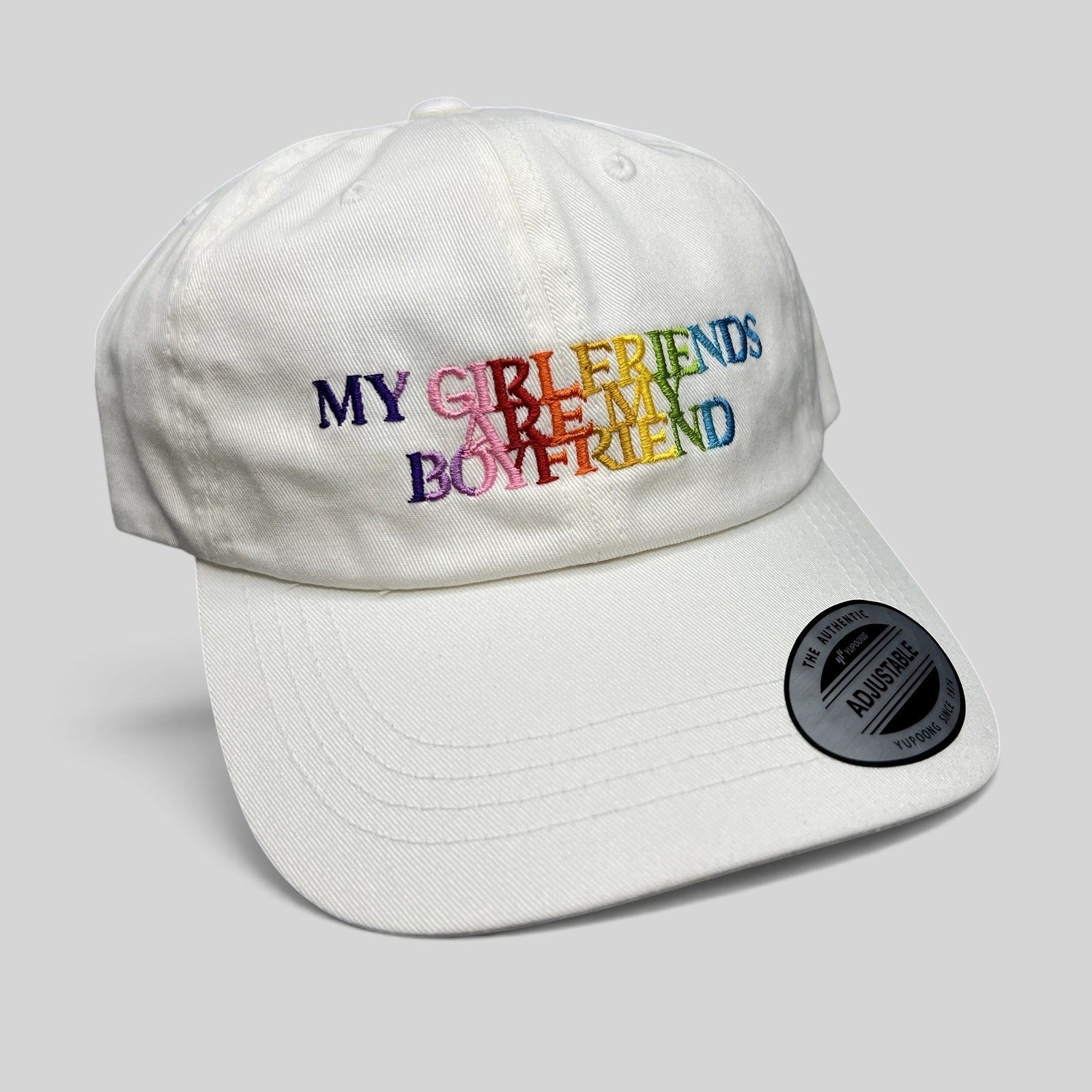 Raree Finds white cotton strapback hat with multicolor embroidered My Girlfriends Are My Boyfriend text and Yupoong tag
