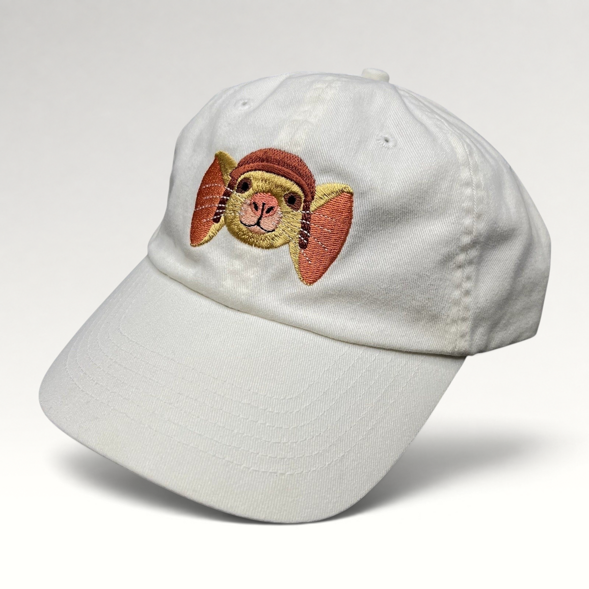 Raree Finds white cotton strapback hat featuring an embroidered Despereaux mouse character from the 2008 movie.