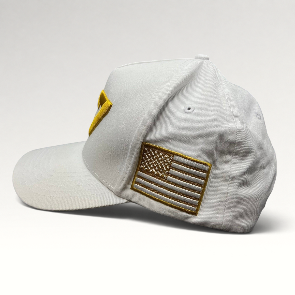 Raree Finds white cotton snapback hat featuring a gold embroidered American flag patch on the side panel.