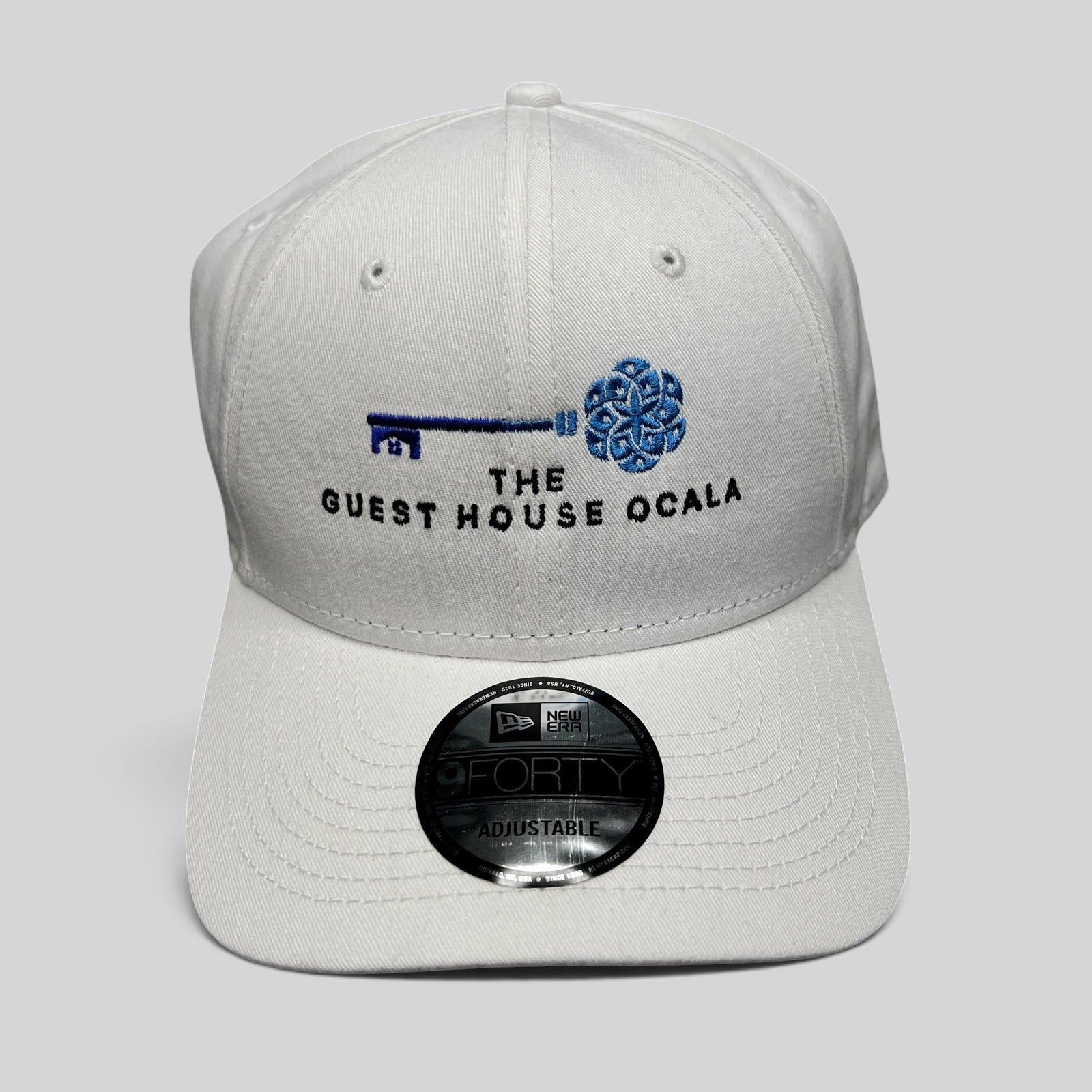 Raree Finds white New Era 9FORTY strapback hat with The Guest House Ocala blue key embroidery and curved brim