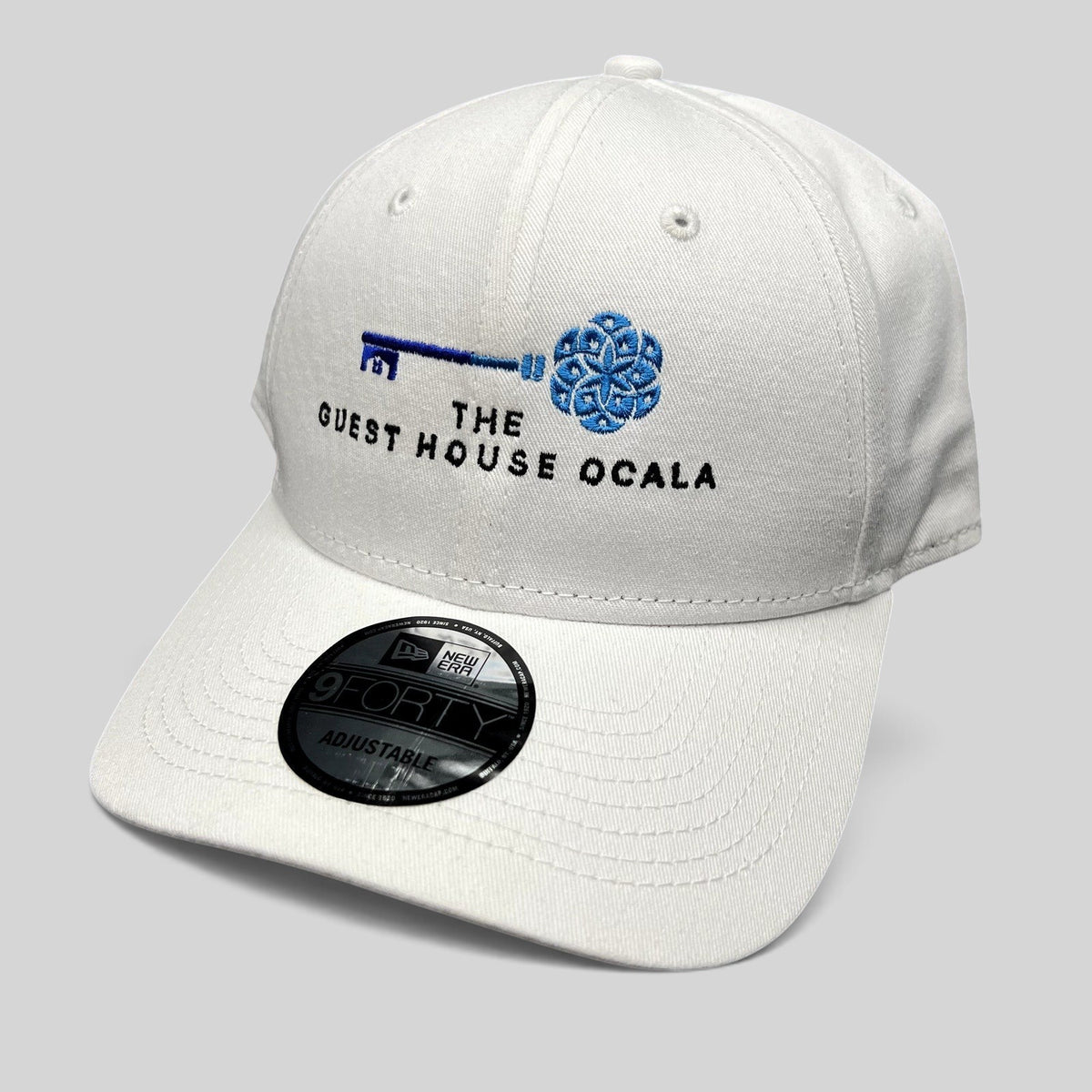 Raree Finds white New Era 9FORTY strapback hat with The Guest House Ocala blue key embroidery and curved brim