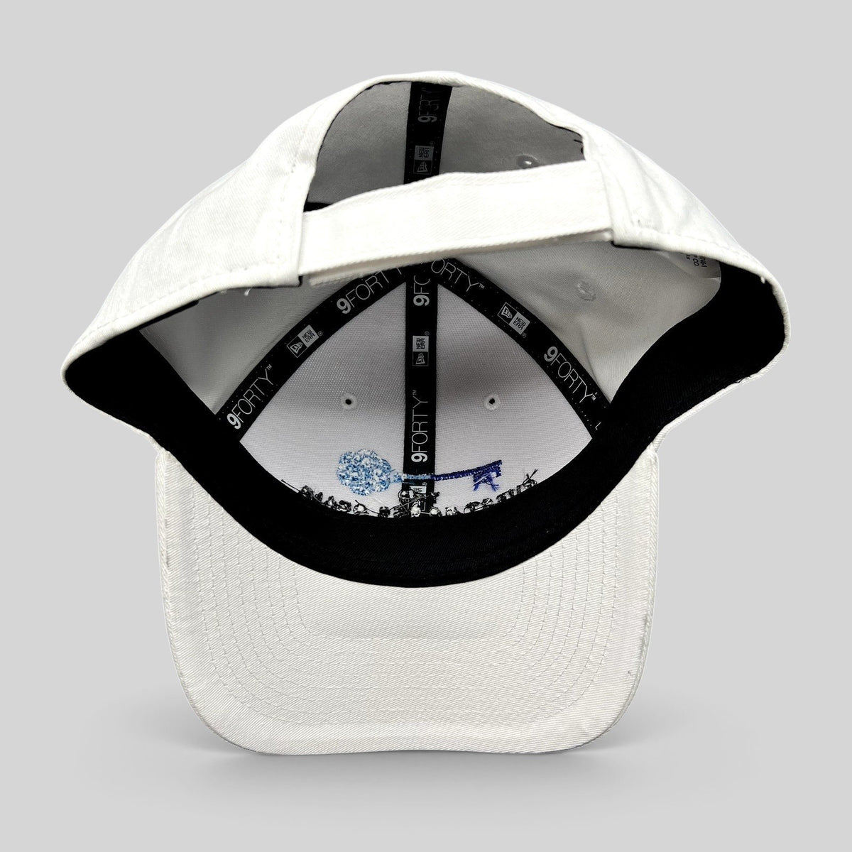 Raree Finds white New Era 9FORTY strapback hat interior view showing branded taping and embroidered key logo