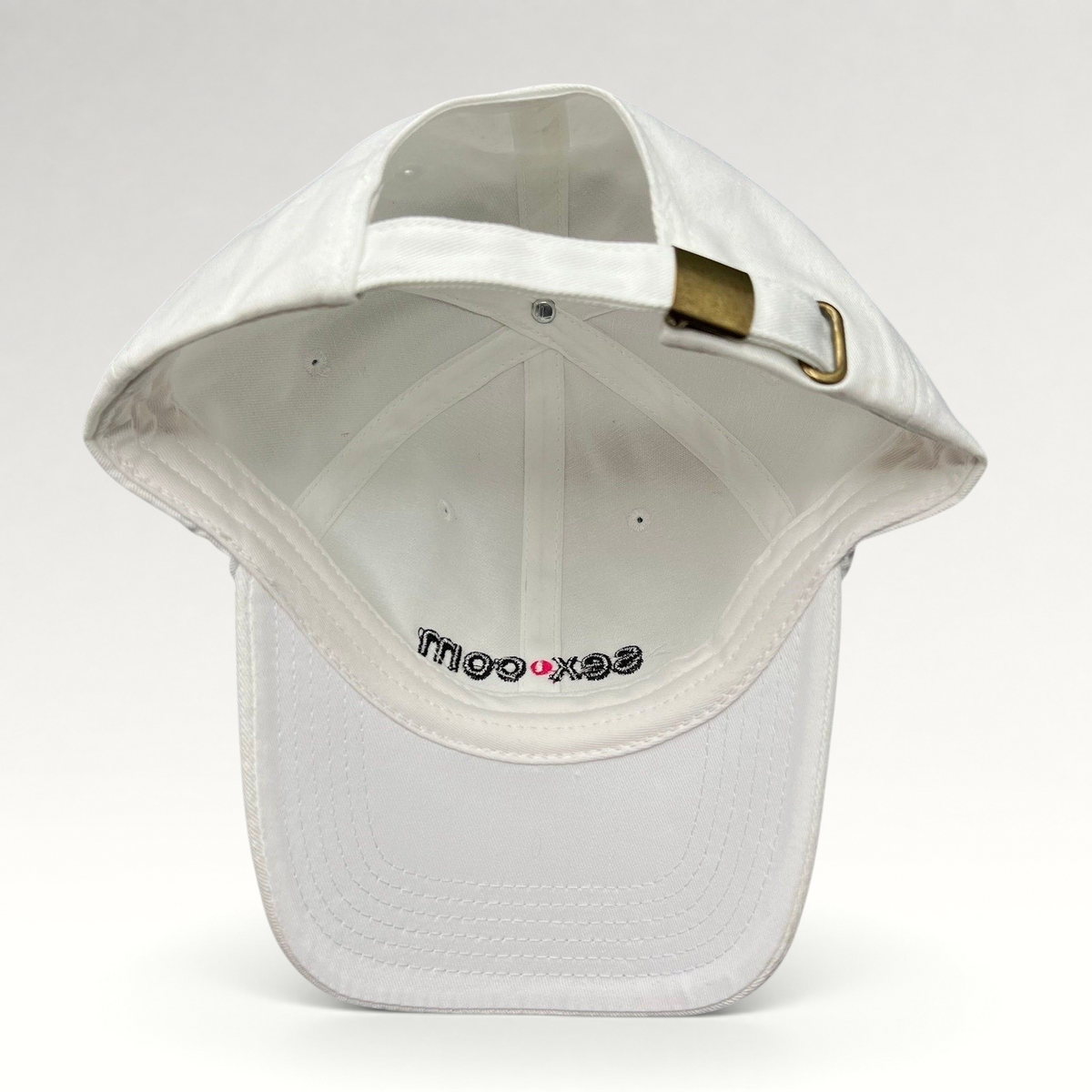 Raree Finds white cotton dad cap with adjustable strapback and brass buckle, showing interior logo embroidery