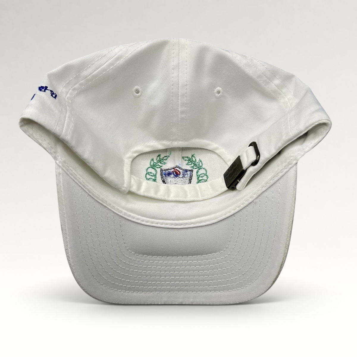 Raree Finds white strapback hat with embroidered crest and adjustable metal buckle closure, back view