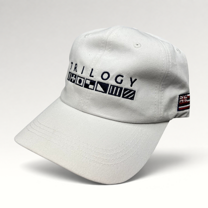 Raree Finds white cotton strapback cap with Trilogy branding and embroidered nautical signal flags on the front.