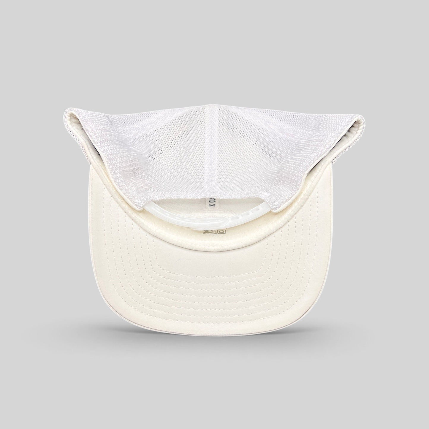 Raree Finds Black Clover white trucker hat interior view showing mesh back and Yupoong Flexfit construction
