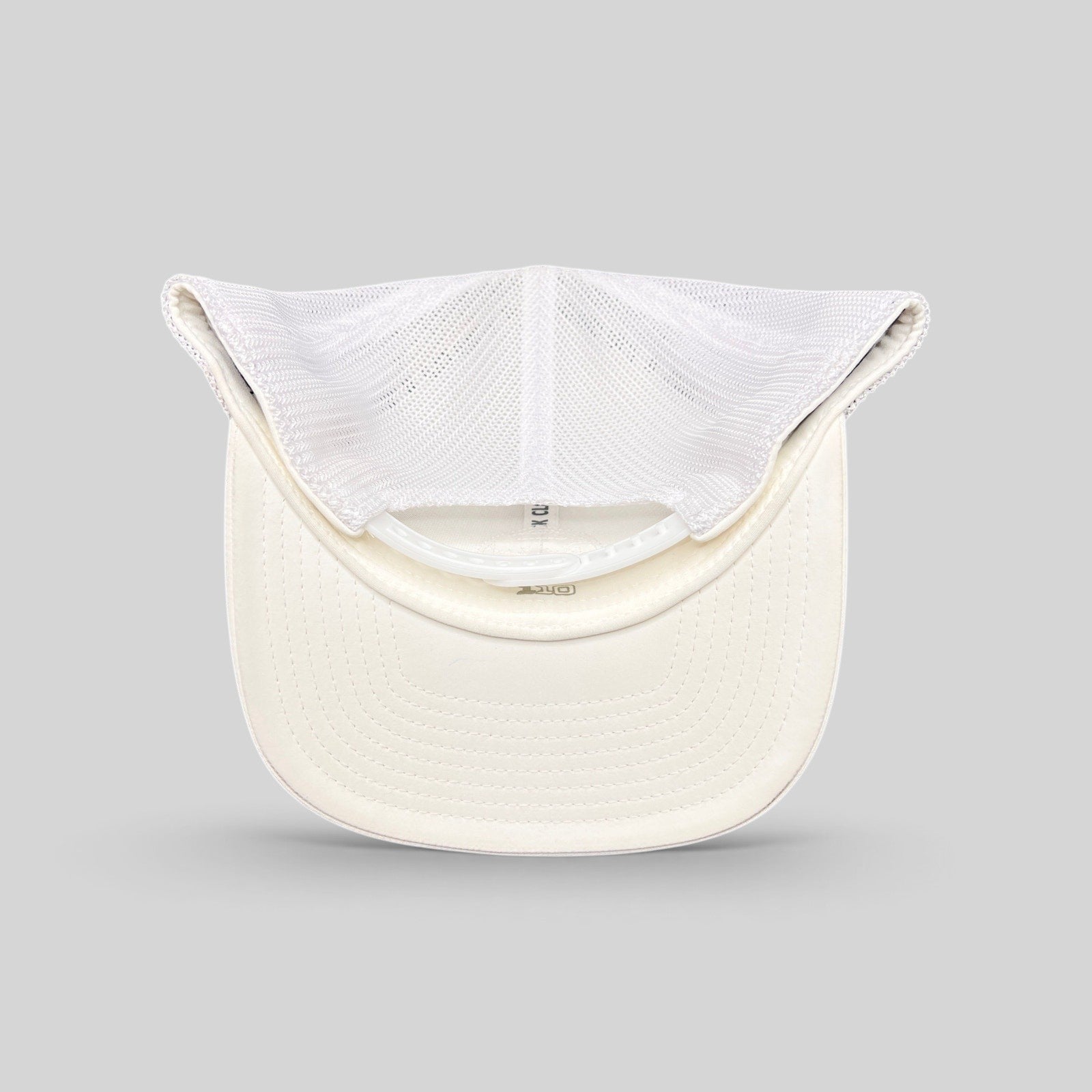 Raree Finds Black Clover white trucker hat interior view showing mesh back and Yupoong Flexfit construction