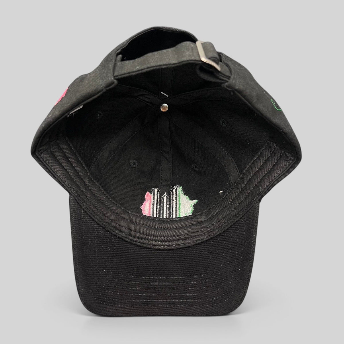 Raree Finds Wicked Broadway musical black cotton strapback hat with green and pink interior embroidery detail