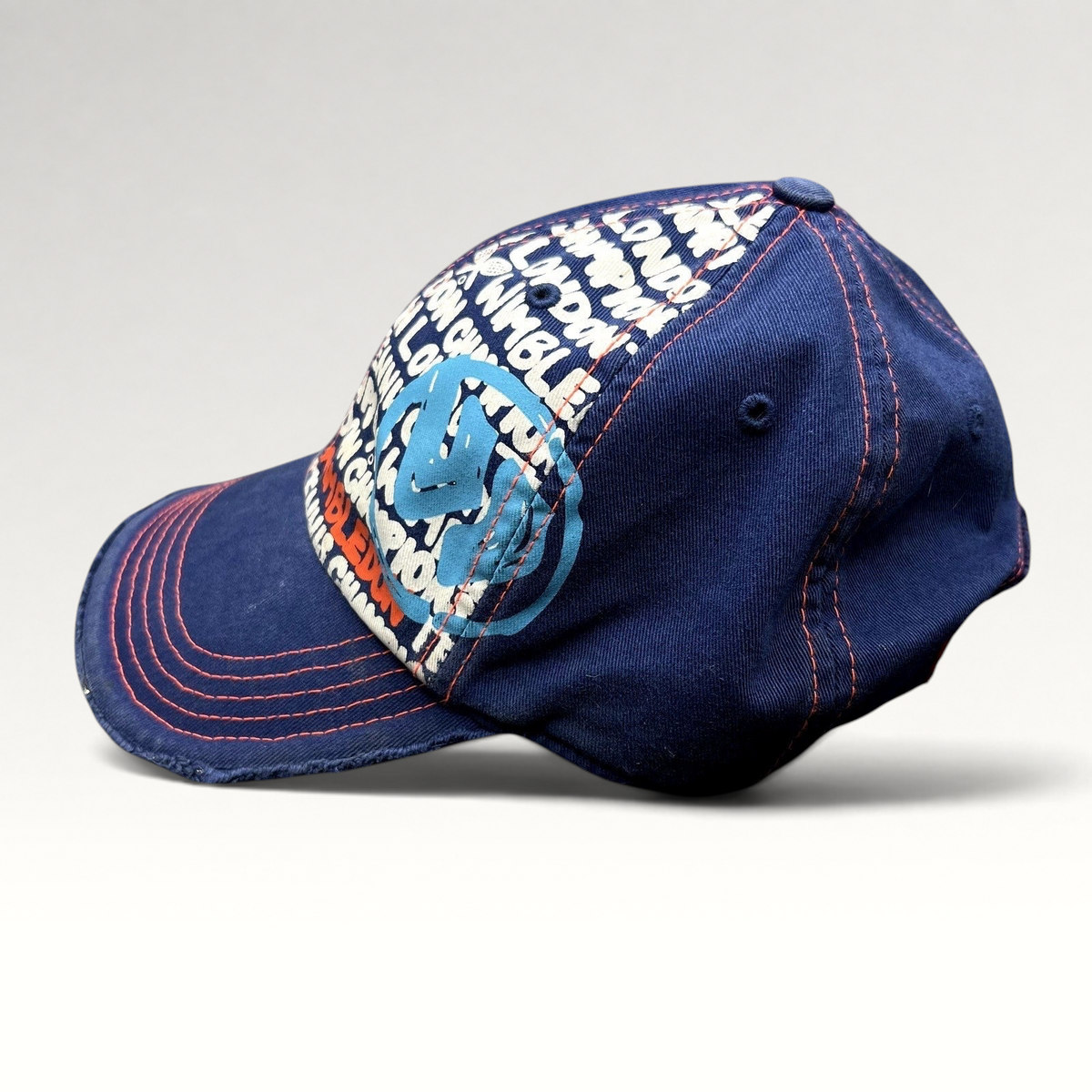 Raree Finds navy and orange distressed Wimbledon strapback hat with graphic tournament print and frayed edge detailing.