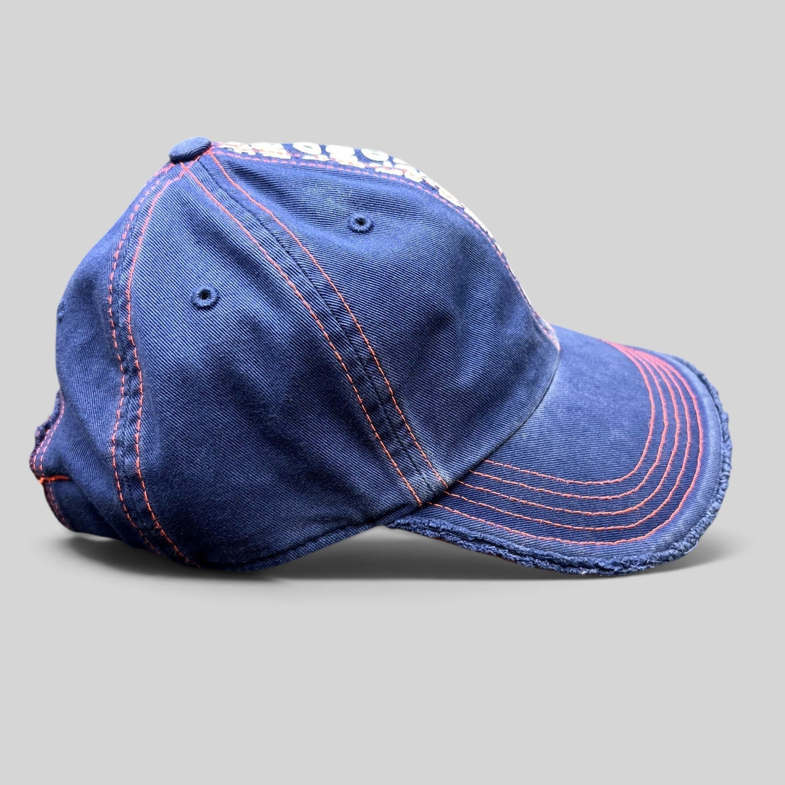 Raree Finds navy blue Wimbledon strapback hat with orange stitching, frayed edges, and graphic tournament print.