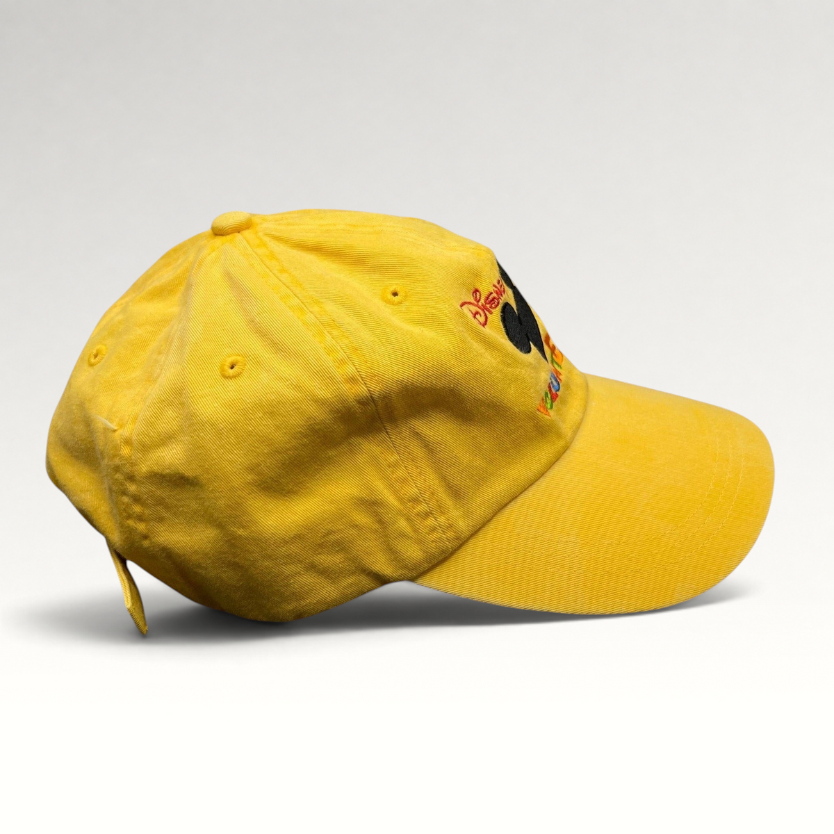 Raree Finds yellow Disney VoluntEARS cotton strapback hat with Mickey Mouse silhouette and colorful embroidery