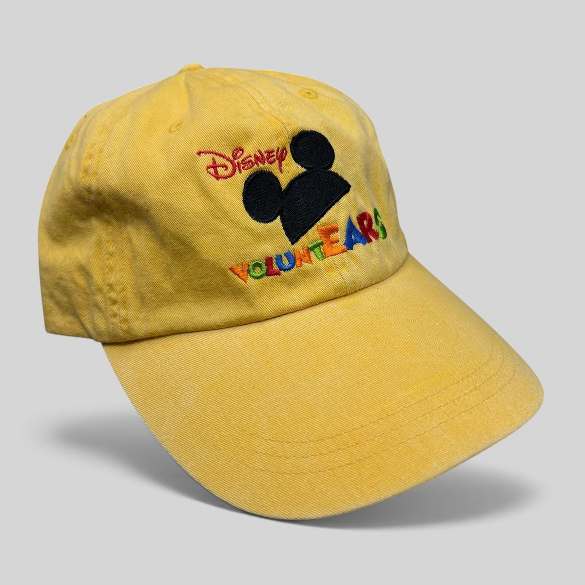 Raree Finds yellow Disney VoluntEARS strapback hat with Mickey silhouette and colorful embroidered logo
