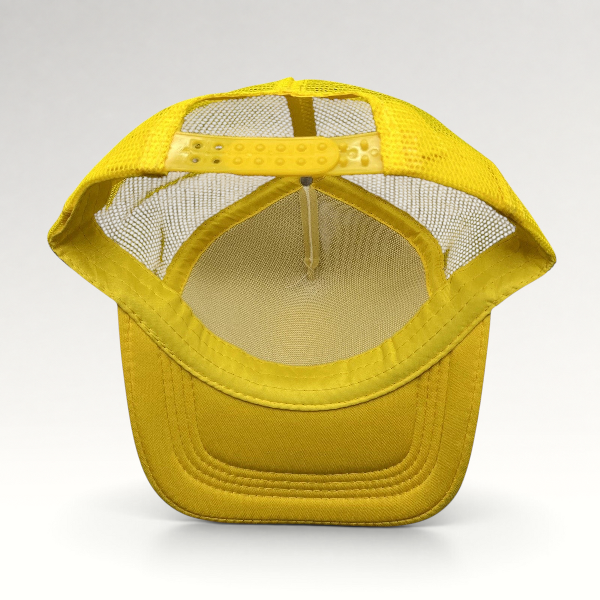 Raree Finds Gold’s Gym yellow trucker hat showing the interior mesh lining and adjustable snapback closure