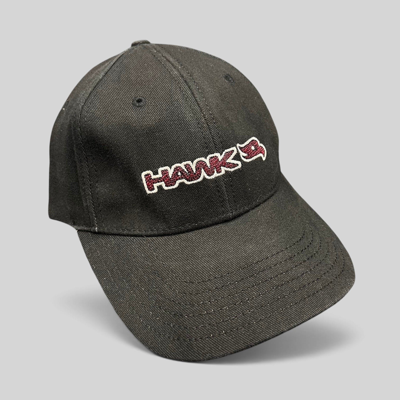 Raree Finds youth fitted black skate hat featuring an embroidered HAWK wordmark and bird logo in red and white.