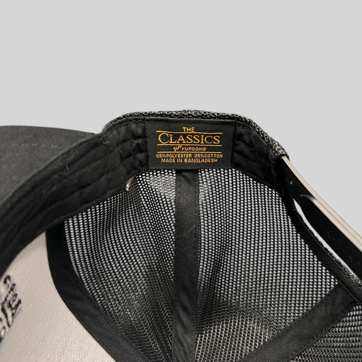 Raree Finds Yupoong Classics snapback hat interior label showing polyester and cotton material composition