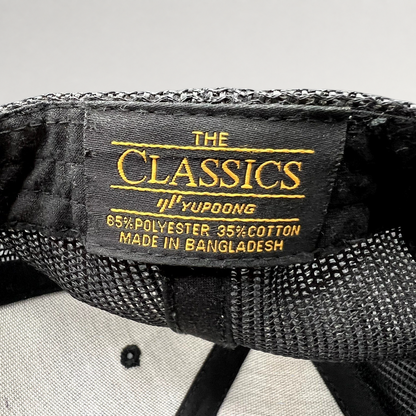Raree Finds black Yupoong Classics trucker hat interior label showing polyester cotton blend and origin details